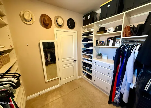 a view of walk in closet with clothes and shoes
