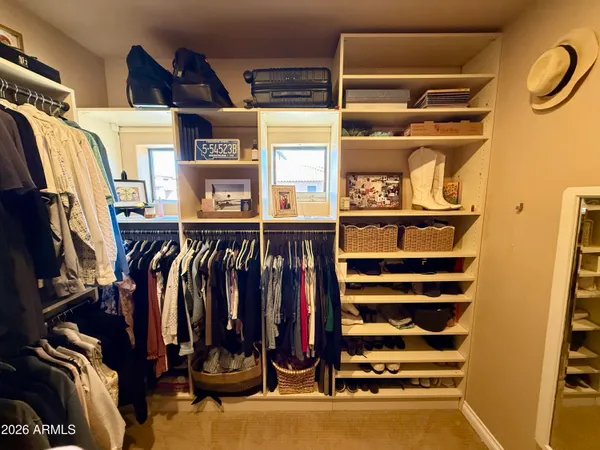 a view of walk in closet with clothes and shoes