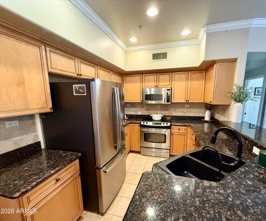 a kitchen with granite countertop a refrigerator stove and sink