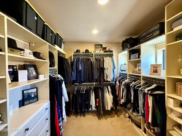 a view of walk in closet with clothes and shoes