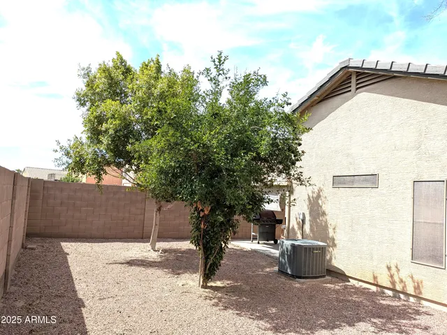 a backyard of a house with table and chairs
