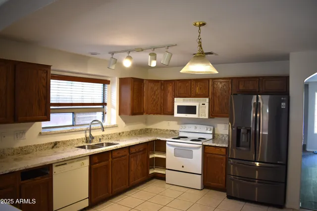 a kitchen with a sink stainless steel appliances and window