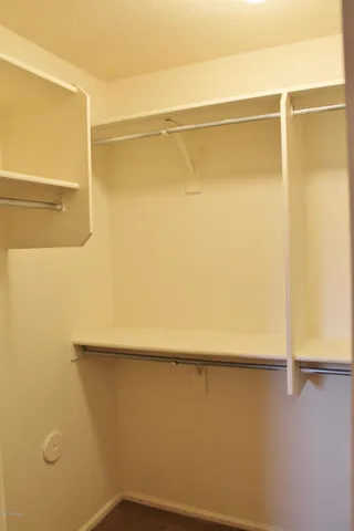 a view of walk in closet with empty racks