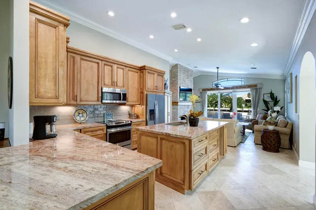 a large kitchen with stainless steel appliances granite countertop a stove oven and a white cabinets