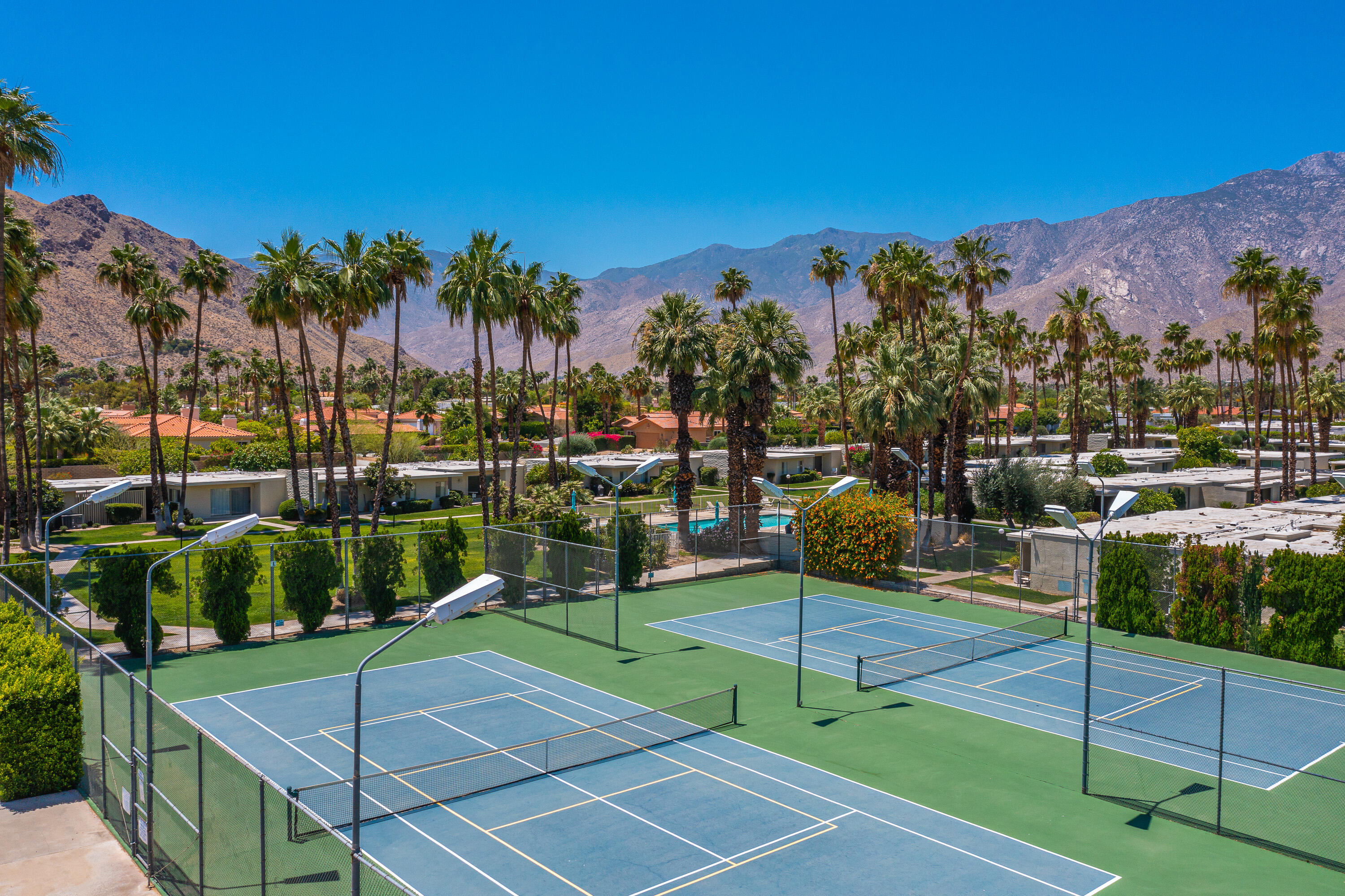 1881 South Araby Drive, Unit 16 Palm Springs, CA 92264 - Photo 42 of 52 a view of a tennis ground with large trees
