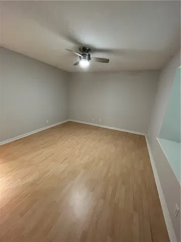 an empty room with a ceiling fan and window
