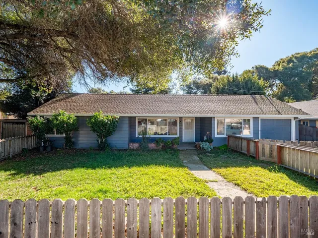 a view of a house with a yard and wooden fence