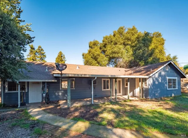 a view of a house with a yard and sitting area