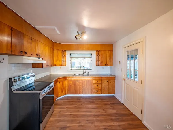 a kitchen with stainless steel appliances granite countertop a sink stove and cabinets