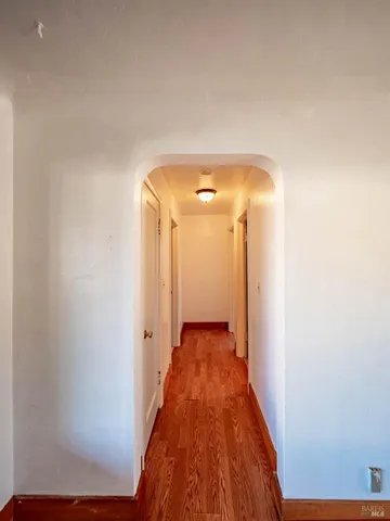 a view of a hallway with wooden floor