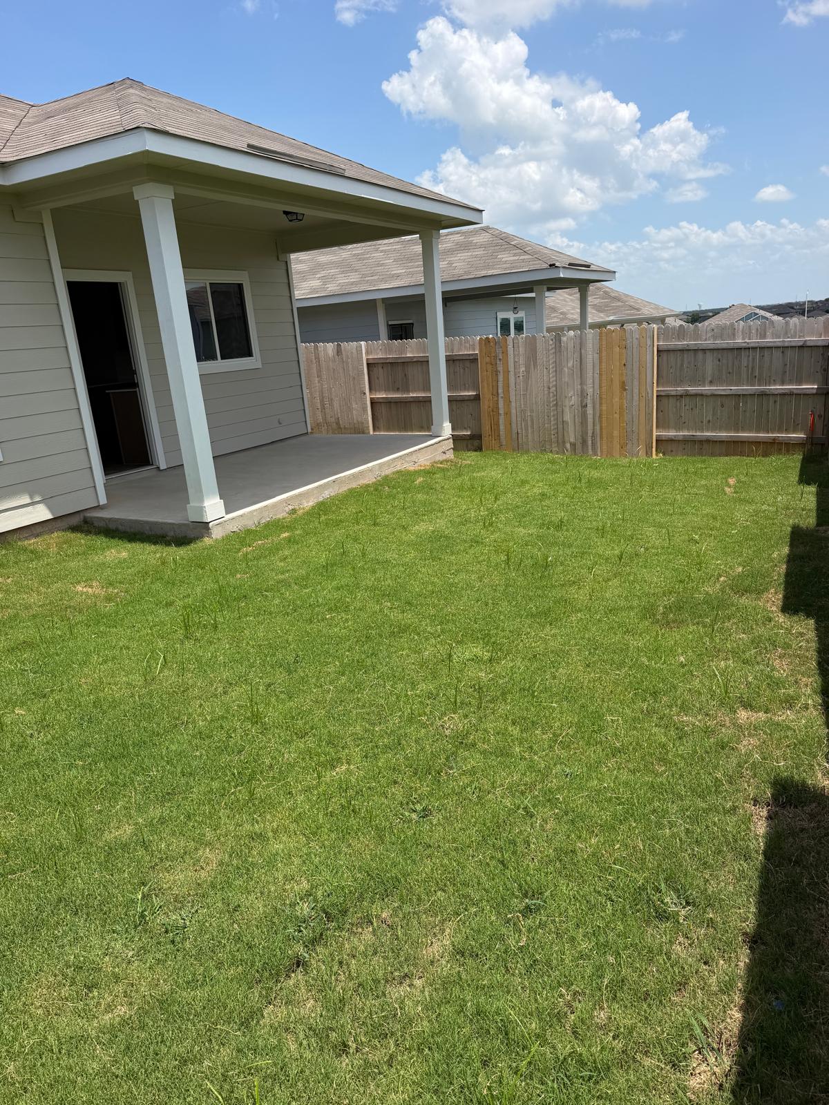 2701 Towy Road Manor, TX 78653 - Photo 31 of 35 A spacious backyard awaits, featuring a covered patio for outdoor enjoyment.