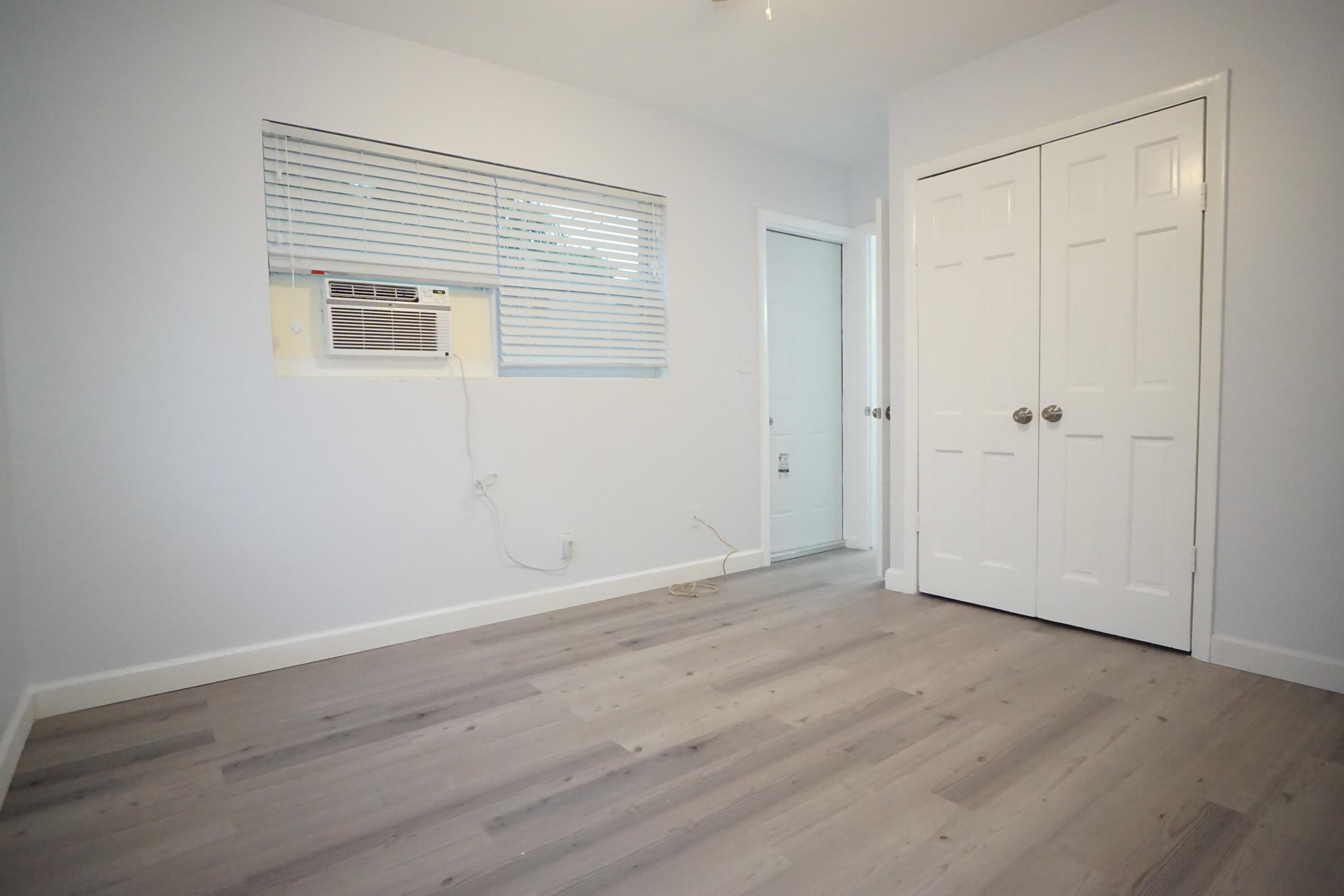 1815 Juno Road, Unit 3 North Palm Beach, FL 33408 - Photo 11 of 15 a view of an empty room with wooden floor and a window