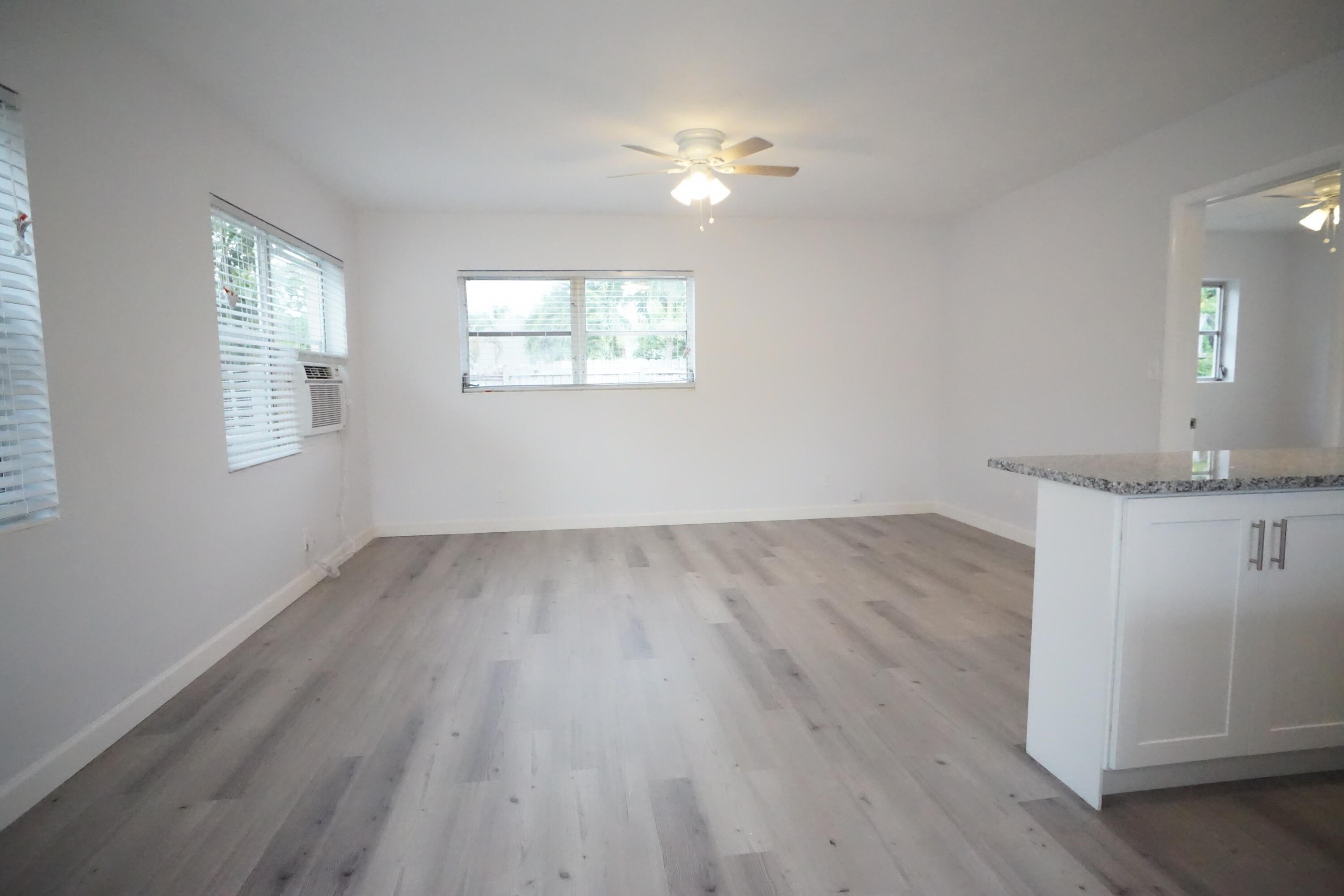 1815 Juno Road, Unit 3 North Palm Beach, FL 33408 - Photo 5 of 15 an empty room with wooden floor and windows