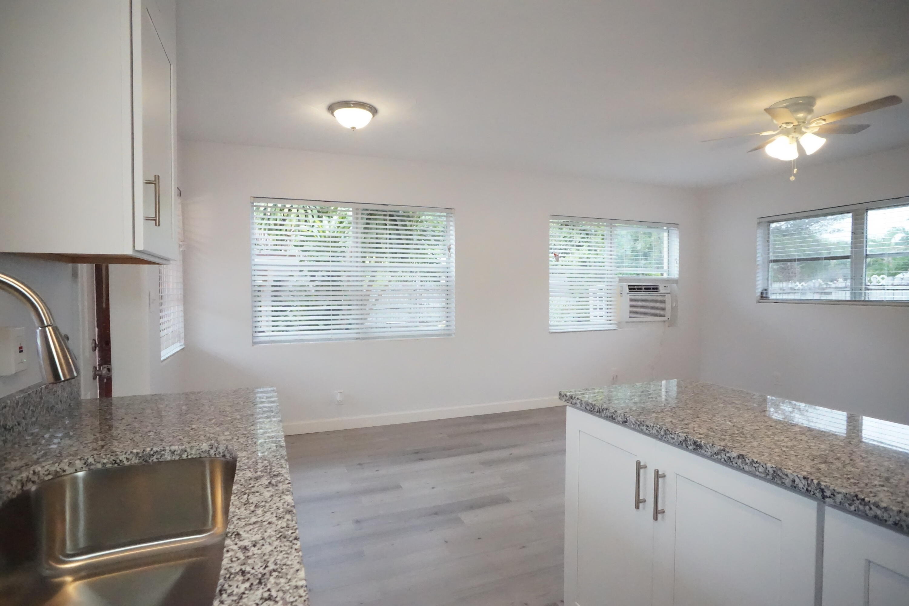 1815 Juno Road, Unit 3 North Palm Beach, FL 33408 - Photo 7 of 15 a kitchen with granite countertop a sink and a window