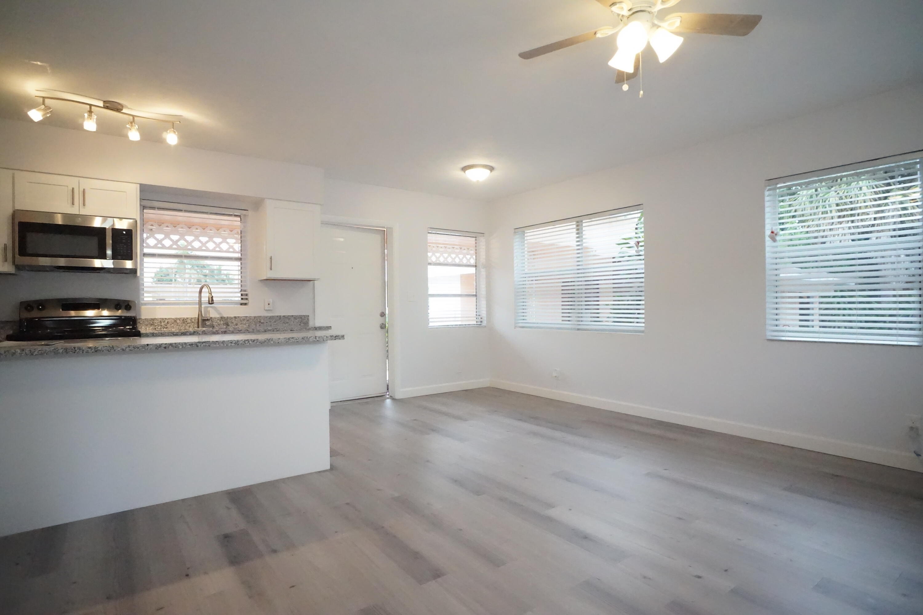 1815 Juno Road, Unit 3 North Palm Beach, FL 33408 - Photo 8 of 15 a kitchen with stainless steel appliances granite countertop a stove a sink and a microwave