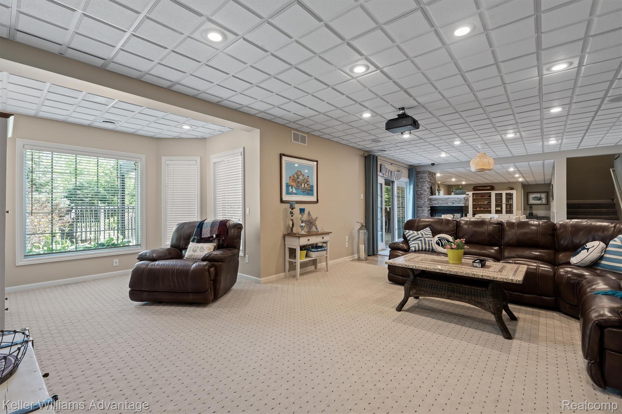 22878 Tree Top Court South Lyon, MI 48178 - Photo 30 of 75 Spacious lower-level living area featuring recessed lighting, a coffered ceiling, and carpeted flooring