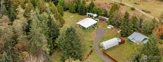 an aerial view of a house with swimming pool and large trees