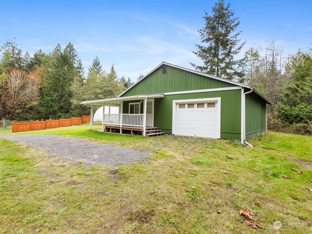 a view of a house with backyard and trees