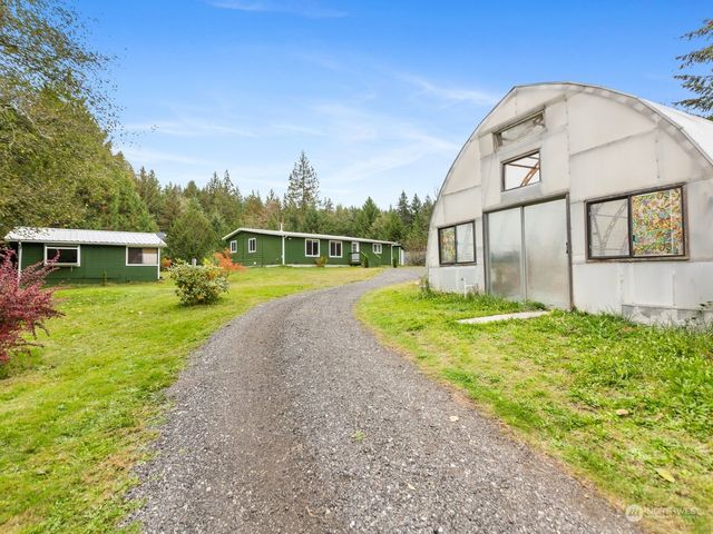 a view of an house with backyard and a tree