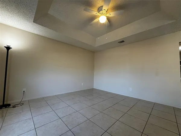 an empty room with a ceiling fan and carpet