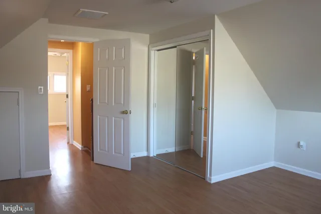 an empty room with wooden floor and a window
