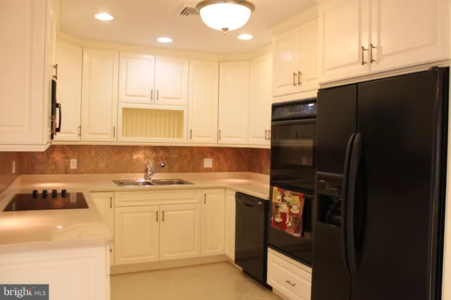 a kitchen with stainless steel appliances granite countertop a refrigerator and a stove