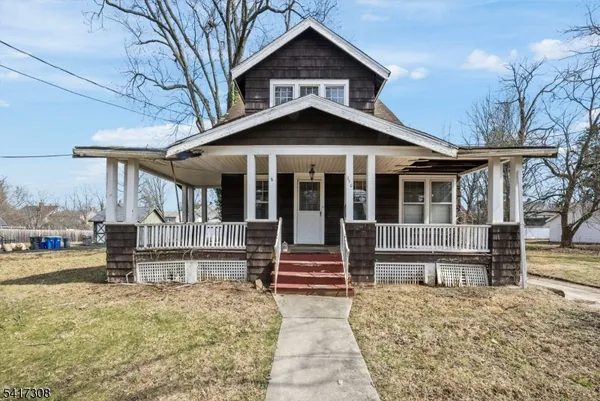 a view of a house with a yard and wooden fence