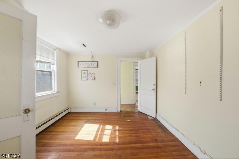 610 Watchung Road Bound Brook, NJ 08805 - Photo 5 of 45 a view of an empty room with window and wooden floor
