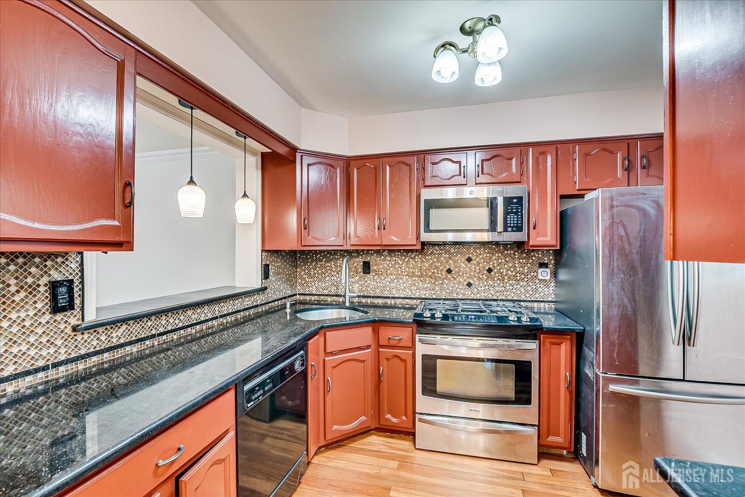 6 Tulip Court Edison, NJ 08820 - Photo 11 of 46 a kitchen with granite countertop stainless steel appliances and wooden cabinets
