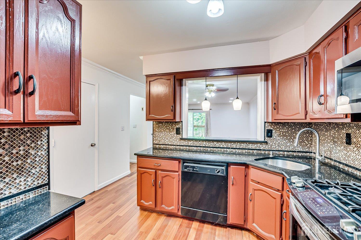 6 Tulip Court Edison, NJ 08820 - Photo 15 of 46 a kitchen with stainless steel appliances granite countertop a stove a sink and a microwave