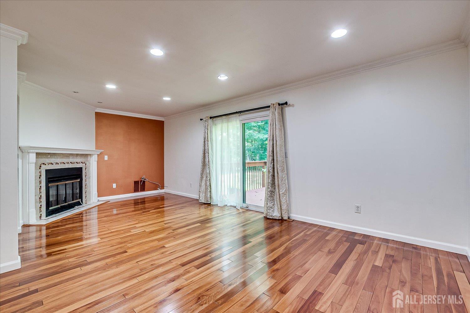 6 Tulip Court Edison, NJ 08820 - Photo 19 of 46 an empty room with wooden floor and fireplace