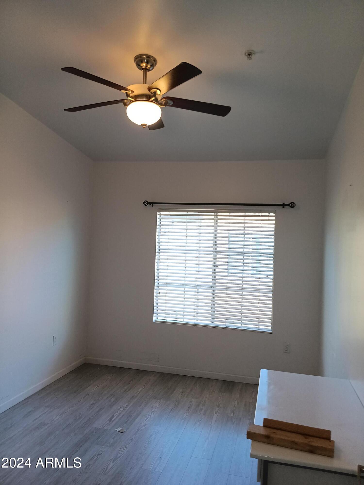1920 East Bell Road, Unit 1103 Phoenix, AZ 85022 - Photo 22 of 29 a view of an empty room with a window and wooden floor