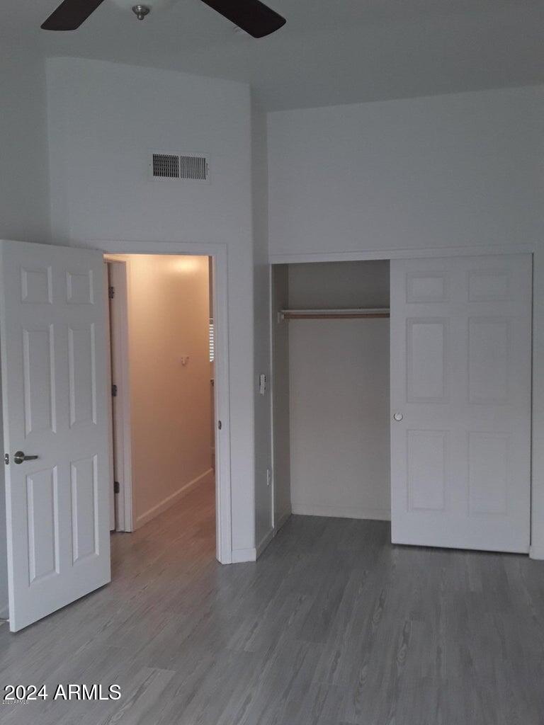 1920 East Bell Road, Unit 1103 Phoenix, AZ 85022 - Photo 24 of 29 an empty room with wooden floor closet and windows