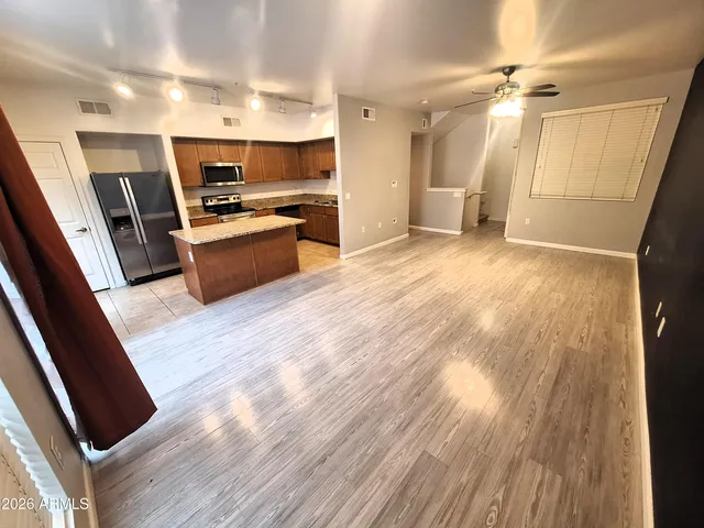 a kitchen with stainless steel appliances a refrigerator a sink dishwasher and a stove top oven