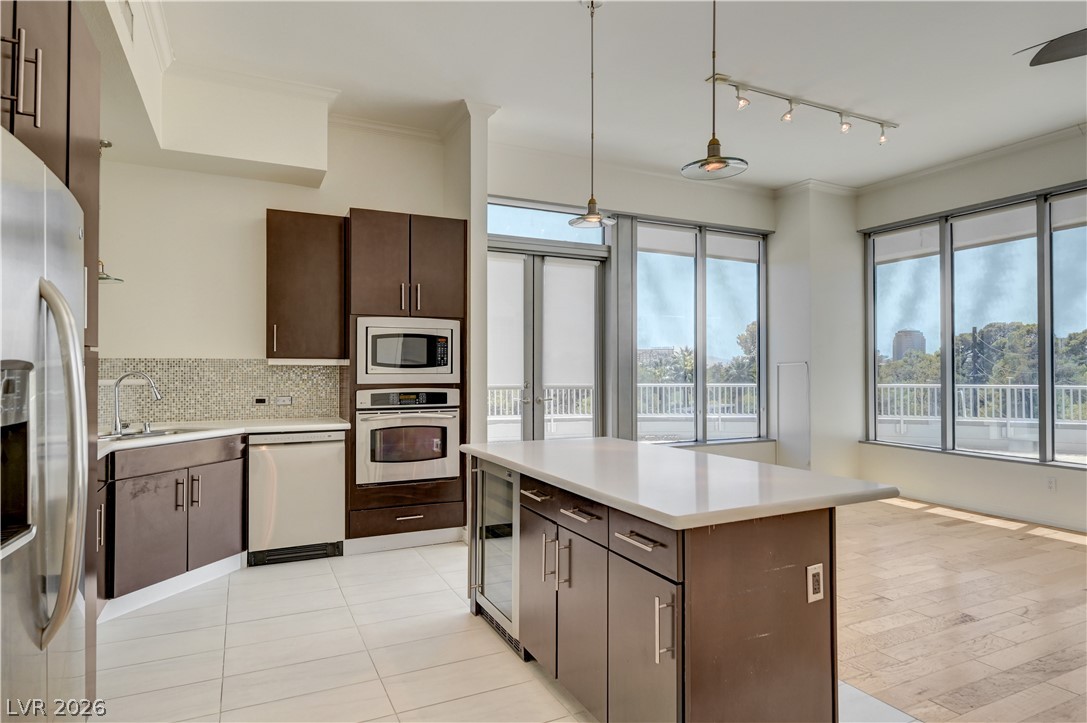360 East Desert Inn Road, Unit 402 Las Vegas, NV 89109 - Photo 8 of 40 A contemporary kitchen space boasts sleek cabinetry, stainless steel appliances, and abundant natural illumination.
