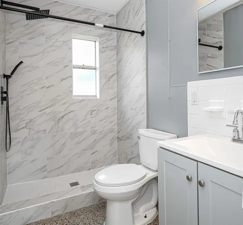a bathroom with a sink a toilet and shower