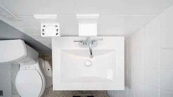 a bathroom with a sink a toilet and mirror