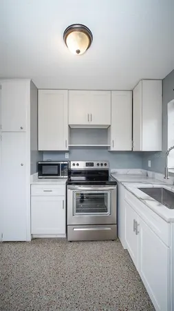 a kitchen with a stove and white cabinets
