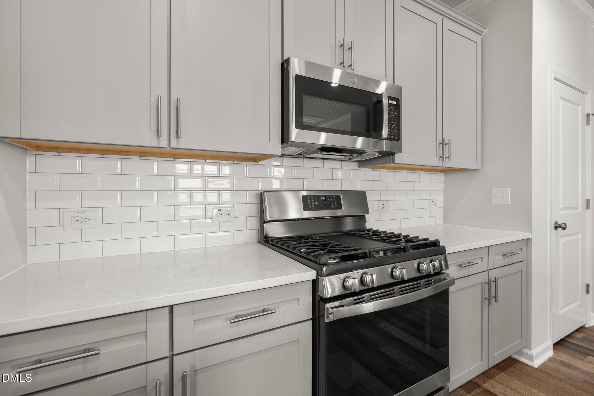 5031 Kota Street Raleigh, NC 27610 - Photo 16 of 84 a kitchen with stainless steel appliances a sink dishwasher stove and microwave with wooden floor