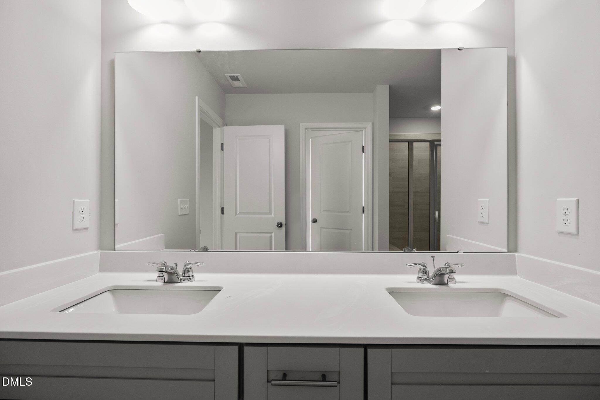 5031 Kota Street Raleigh, NC 27610 - Photo 34 of 84 a bathroom with double sink and a mirror