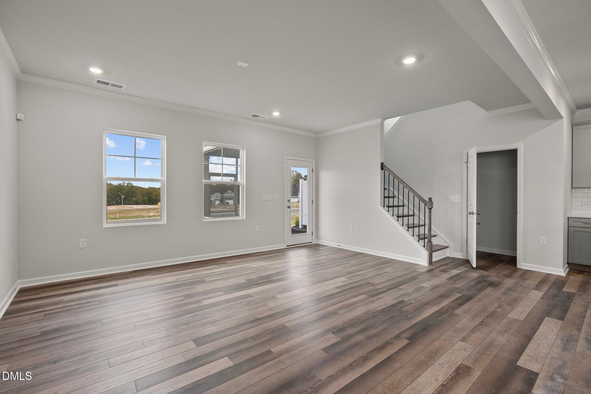 5031 Kota Street Raleigh, NC 27610 - Photo 6 of 84 a view of an empty room with wooden floor and stairs