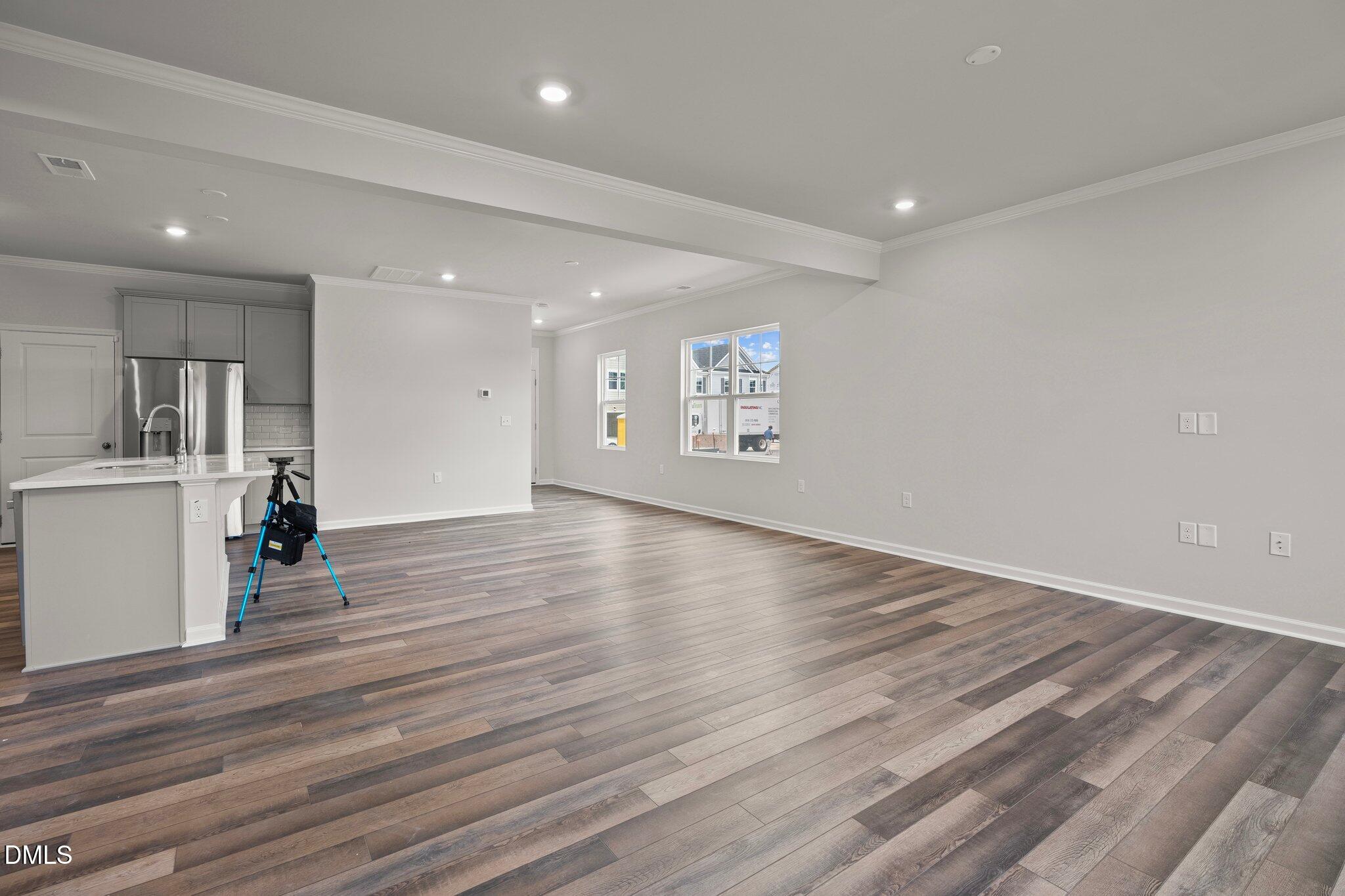 5031 Kota Street Raleigh, NC 27610 - Photo 10 of 84 a view of an empty room with wooden floor and a kitchen