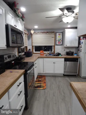 a kitchen with stainless steel appliances a sink stove top oven and cabinets