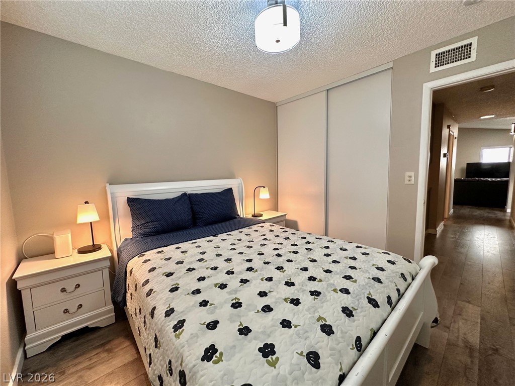 2340 Viewcrest Road Henderson, NV 89014 - Photo 21 of 36 This inviting bedroom features rich flooring and a spacious closet, offering comfort and convenience.