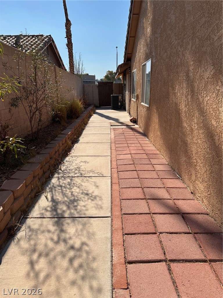 2340 Viewcrest Road Henderson, NV 89014 - Photo 36 of 36 This outdoor pathway features a mix of concrete and brick pavers, leading to the back of the property.