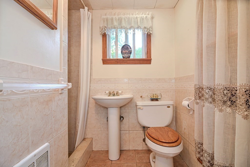 553 Winter Street Walpole, MA 02081 - Photo 41 of 42 a bathroom with a toilet sink and mirror
