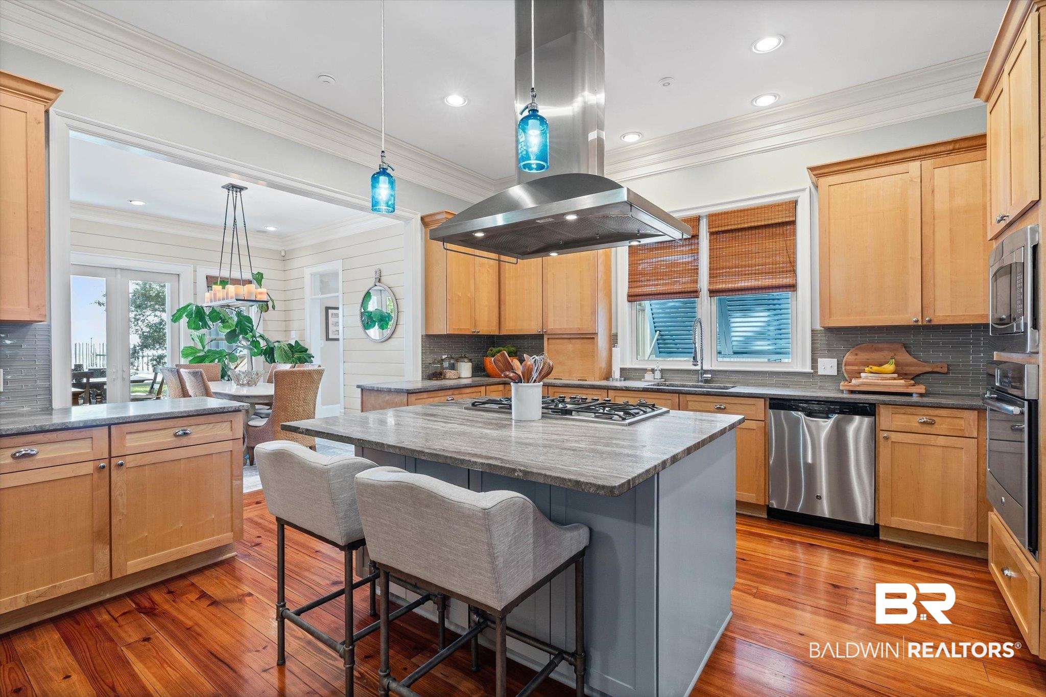 7015 Bay Road Mobile, AL 36605 - Photo 9 of 53 Kitchen featuring island range hood, tasteful backsplash, ornamental molding, a kitchen island, and dark stone counters