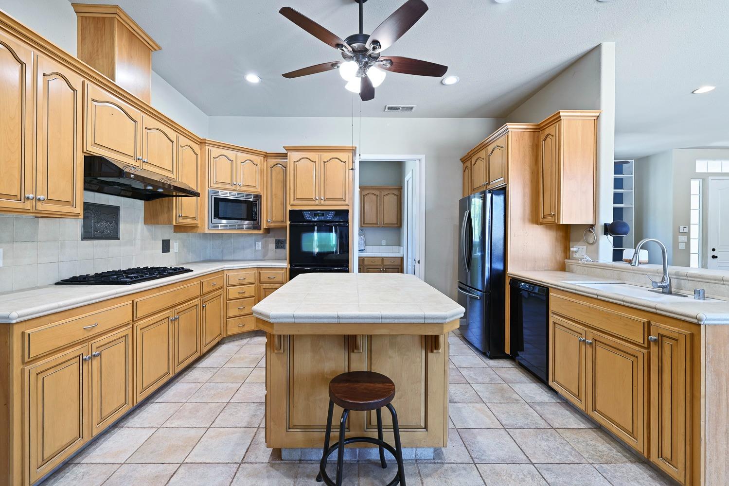 16787 Monreal Road Madera, CA 93636 - Photo 11 of 35 a kitchen with stainless steel appliances a sink stove and cabinets