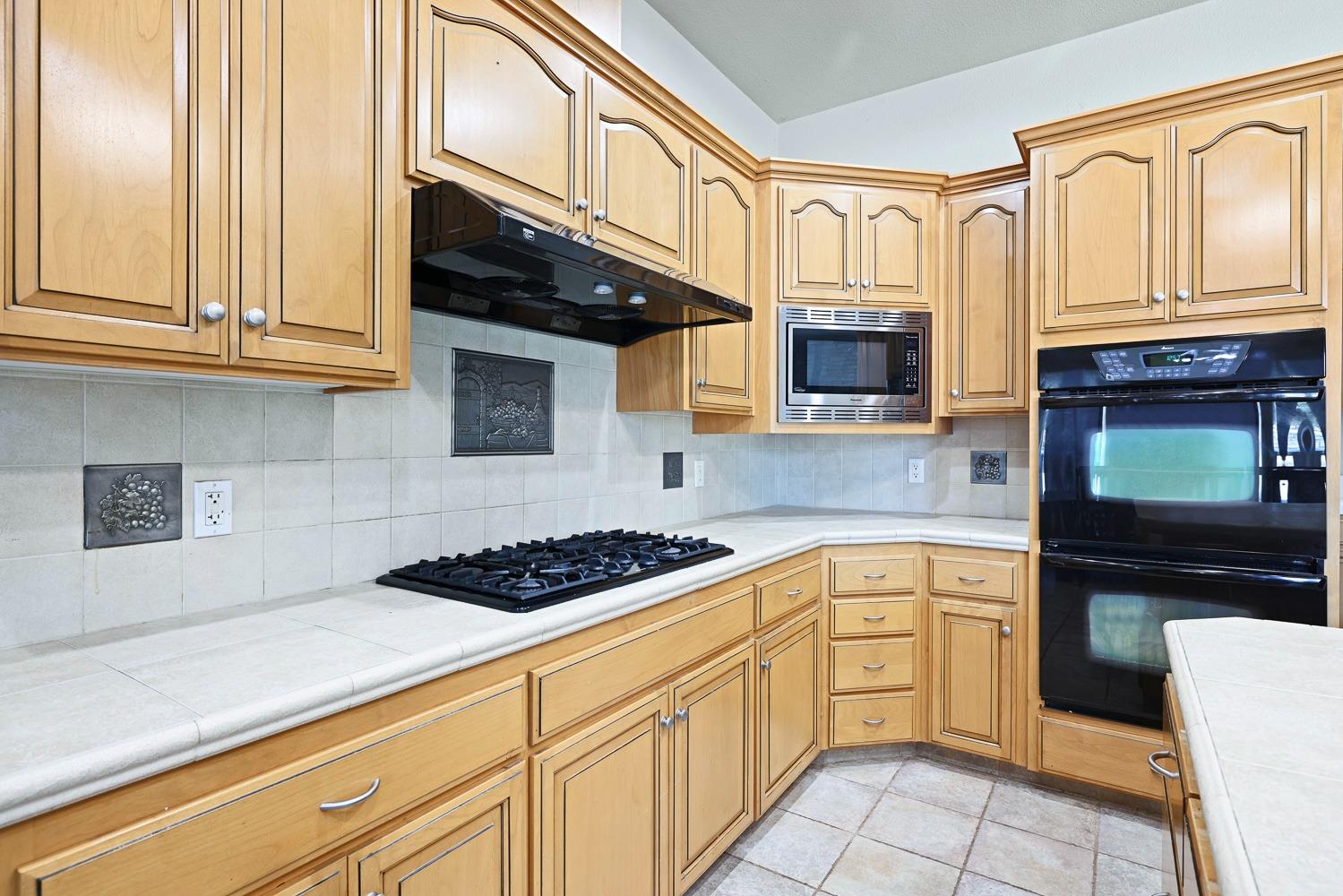 16787 Monreal Road Madera, CA 93636 - Photo 12 of 35 a kitchen with stainless steel appliances granite countertop a stove and a microwave