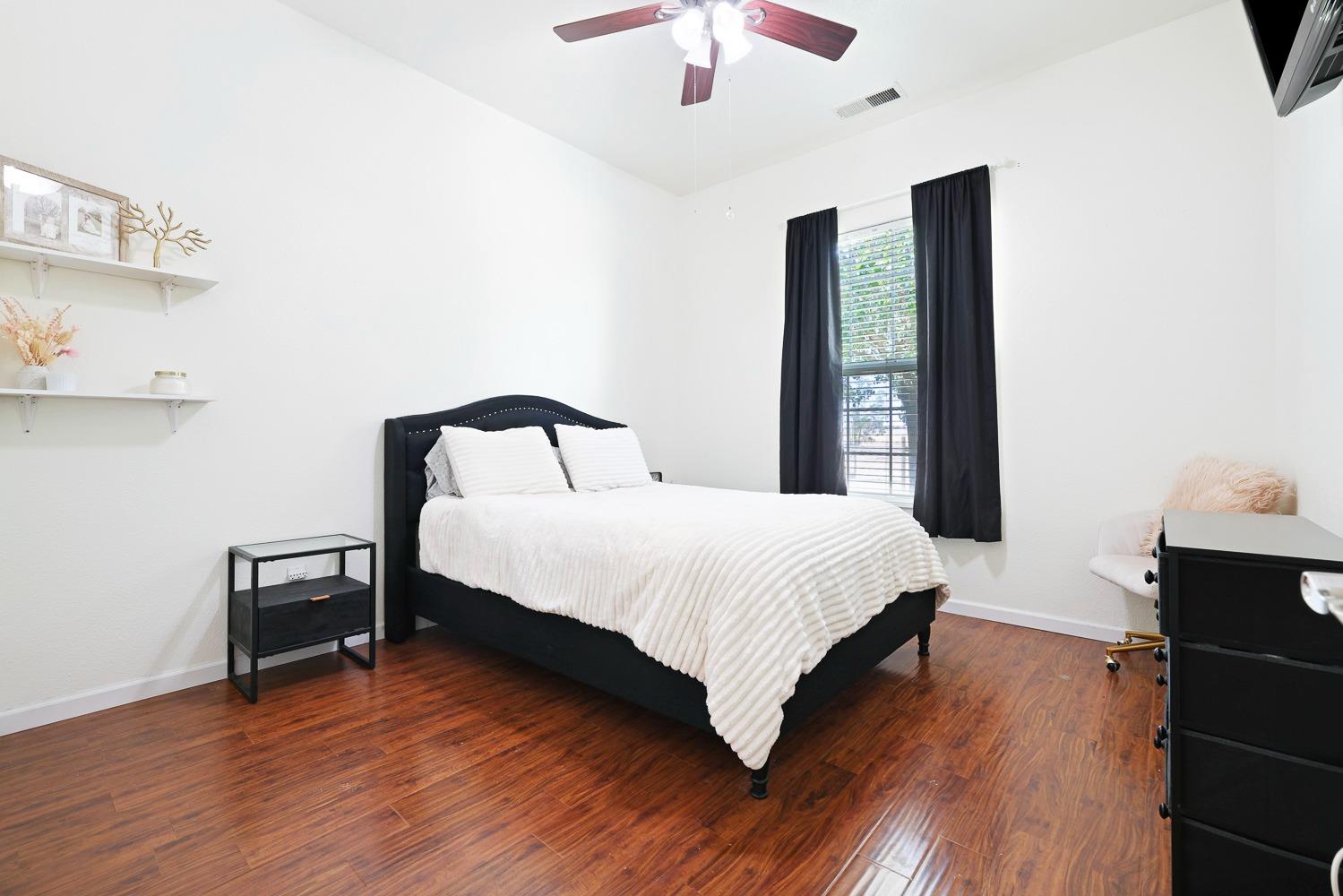 16787 Monreal Road Madera, CA 93636 - Photo 15 of 35 a bedroom with a bed and a chandelier